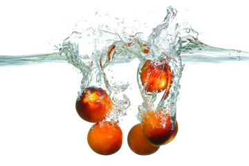 Fresh Tomatoes Splashing Into Water Creating Dynamic Bubbles and Waves