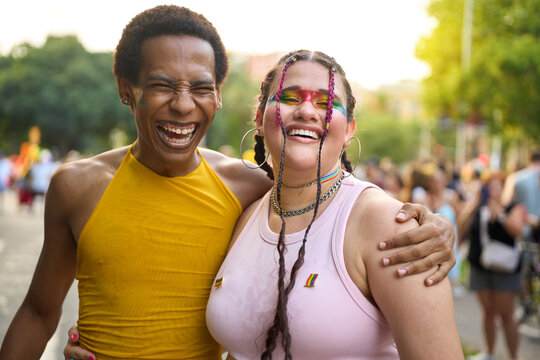 Happy couple laughing and embracing at pride festival