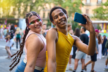 Happy couple taking selfie at pride festival