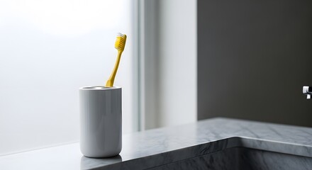 Modern bathroom interior with a yellow toothbrush in a holder on a marble vanity next to a frosted window.
