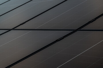 Detailed close-up image of a solar panel's surface showing the texture and structure of photovoltaic cells under natural light.