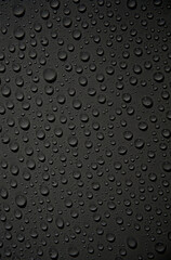 Wassertropfen auf schwarzer Oberfläche als Hintergrund