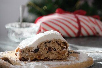 A delicious looking baked treat presented on a wooden board, showcasing various nuts and dried fruits. Christmas stollen. Traditional German sweet bread.