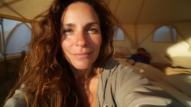 Tourist taking selfie in glamping tent with golden light