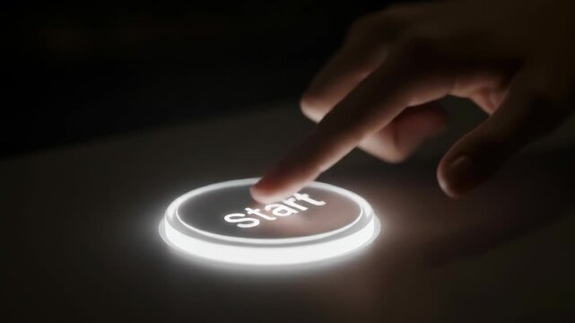 Illuminated Start Button Activation - The video depicts a close-up view of a glowing "Start" button being pressed by a finger.