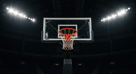 A basketball hoop under bright arena lights, ready for the game.