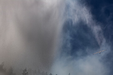 A firefighting plane dumps water on a forest fire in Galicia.