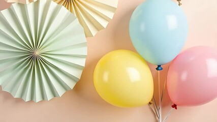 Pastel balloons and paper fans create a soft, dreamy mood for celebrations and party invites