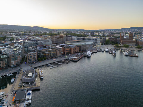 Aerial view of the Oslo City Hall and Aker Brygge waterfront contrasting with the deep blue waters of the Oslofjord, Oslo, Norway.