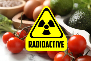 Fresh vegetables on white marble table and radioactive sign. Environmental contamination, polluted...