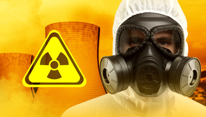 Radioactive hazard, warning sign. Man in hazmat suit and gas mask against industrial plant