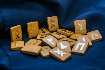 wooden runes lie on a dark background close-up	
