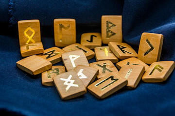Wooden runes lie on a black background	
