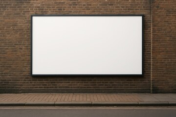 Blank rectangular billboard mounted on a brown brick wall. Street pavement visible below. Natural daylight. Concept of urban advertising and outdoor communication