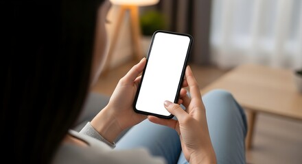 Woman holding a smartphone with a blank white screen in a cozy living room setting indoors at daytime on transparent background