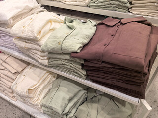 Freshly folded linen shirts neatly organized in a retail setting