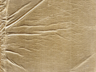 Textured gold paper with a crinkled surface. The reflective material creates a shiny, metallic appearance, with horizontal and vertical creases adding depth.