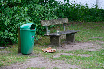 Park Bench with Trash Can and Litter in Flensburg ostseebad