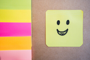 Happy face drawn on colored paper with black marker with a uniform solid background