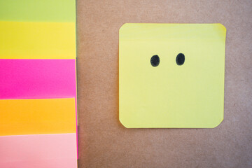 Mouthless face drawn on colored paper with black marker with a uniform solid background