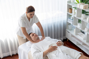 Obraz premium Caucasian man customer enjoying relaxing anti-stress spa massage and pampering with beauty skin recreation leisure in day light ambient salon spa at luxury resort or hotel. Quiescent