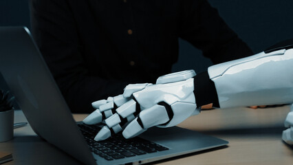 A close-up of a robotic hand interacting with a laptop, showcasing the blend of advanced technology...