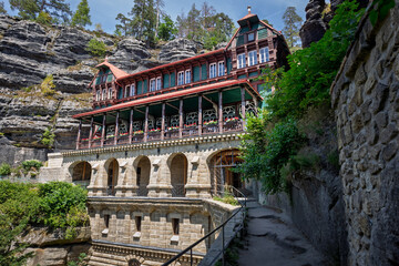 View of the restaurant and hotel high on the mountain near the largest sandstone bridge in Europe,...