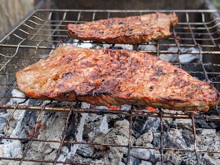 Juicy steaks sizzling on the grill as twilight descends in a backyard barbecue gathering