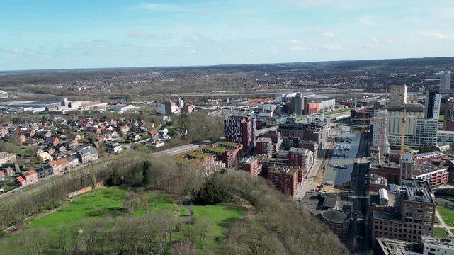 Aerial view of the cityscape reveals a vibrant mix of old and new architecture, with the Dijle river snaking through, Leuven, Flanders, Belgium.