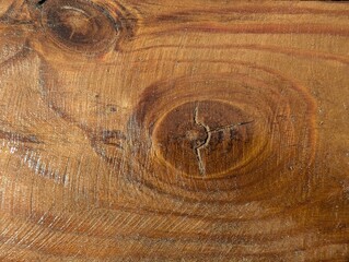 Swirling patterns beneath sunlight reveal the beauty of wood grain in a rustic workshop setting during the golden hour