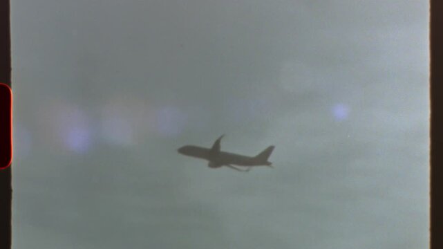 Filmed on super 8 film - airplane flying in a cloudy sky, with a retro 8mm or super 8 film effect and light leaks, creating a nostalgic and classic aesthetic