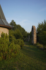 a stone church with a tall steeple and a clock on it. The church has a sloped roof and is situated...