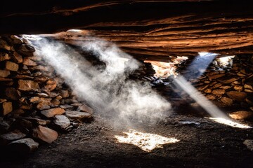 Sunlight streams through openings in a stone structure.