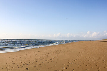 Sandy Coastal Path Leading to the Sea at Sunset Beach Trail through Dunes to Ocean Horizon Natural Sand Dunes and Peaceful Shoreline Landscape North Sea Coast with Grassy Dunes and Blue Sky Scenic