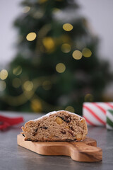 A delicious looking baked treat presented on a wooden board, showcasing various nuts and dried fruits. Christmas stollen. Traditional German sweet bread.