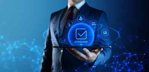 Businessman Holding tablet with Standards Icons on Screen. Quality Management concept