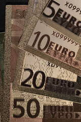 Stack of Various Euro Banknotes Arranged on a Black Background