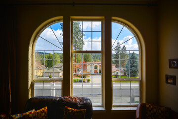 View through a large arched window of waterfront residential homes along the Spokane River in the Post Falls Coeur d'Alene area of North Idaho, USA.