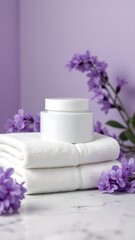 Lavender flowers and cream on a soft towel