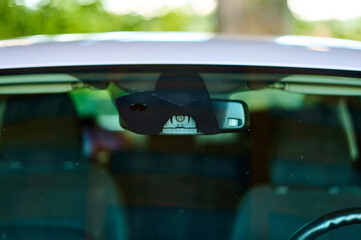 Close-up shot of modern vehicle's interior showing rearview mirror with integrated camera system during daylight, emphasizing advanced automotive technology