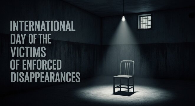 Empty chair under spotlight in dark room for International Day of the Victims of Enforced Disappearances