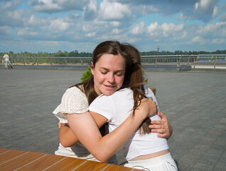 Two girls hugging in the cafe