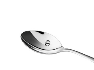 A stainless-steel spoon resting diagonally with a small droplet of water on its bowl, on white background