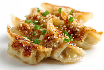 Crispy fried gyoza dumplings isolated on white background topped with scallions
