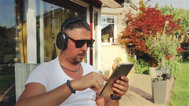 Man engaged with tablet in garden