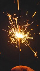 Close Up Hand Holding Burning Festive Sparkler Emitting Intense Gold Sparks In Dark