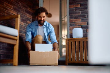 Happy man picking up delivered packages on front porch.
