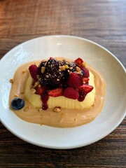 Creamy Dessert with Fresh Berries and Crumbs on a Plate