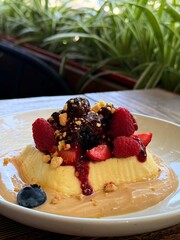 Creamy Dessert with Fresh Berries and Crumbs on a Plate
