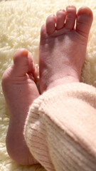 Close-up of tiny, cute, bare feet and toes, heels, and feet of a newborn baby.